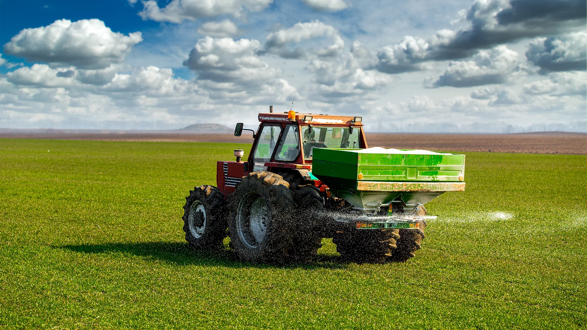 Trator realizando aplicação de adubo no cultivo