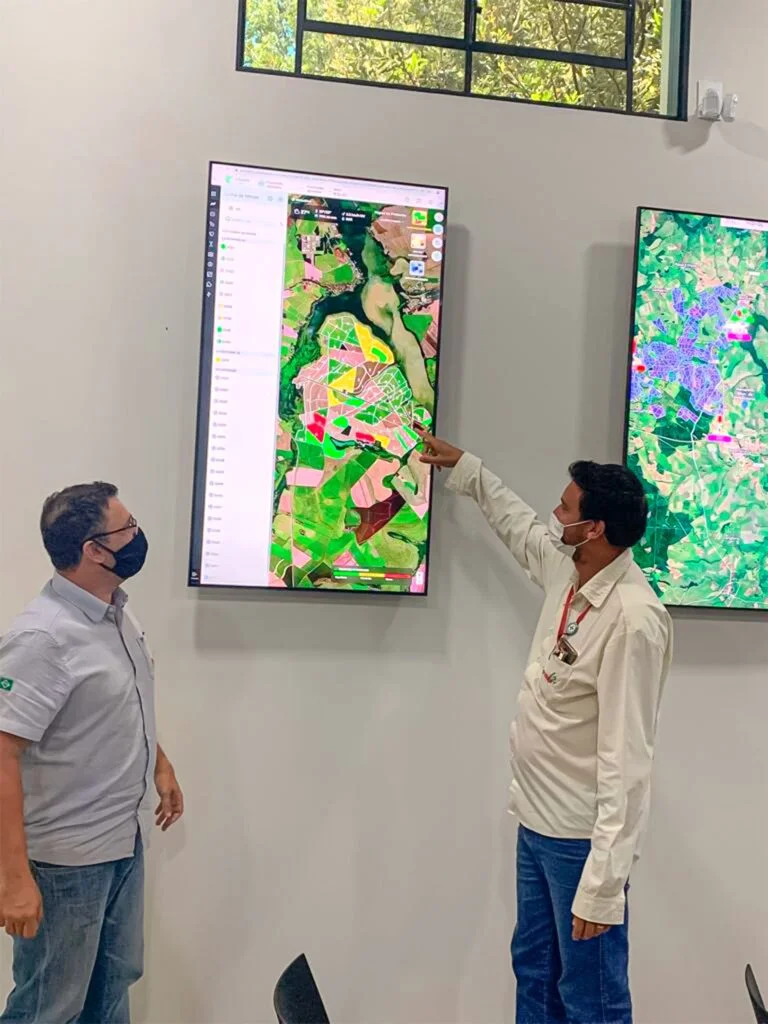 2 homens observando um painel de análise de proteção de plantações